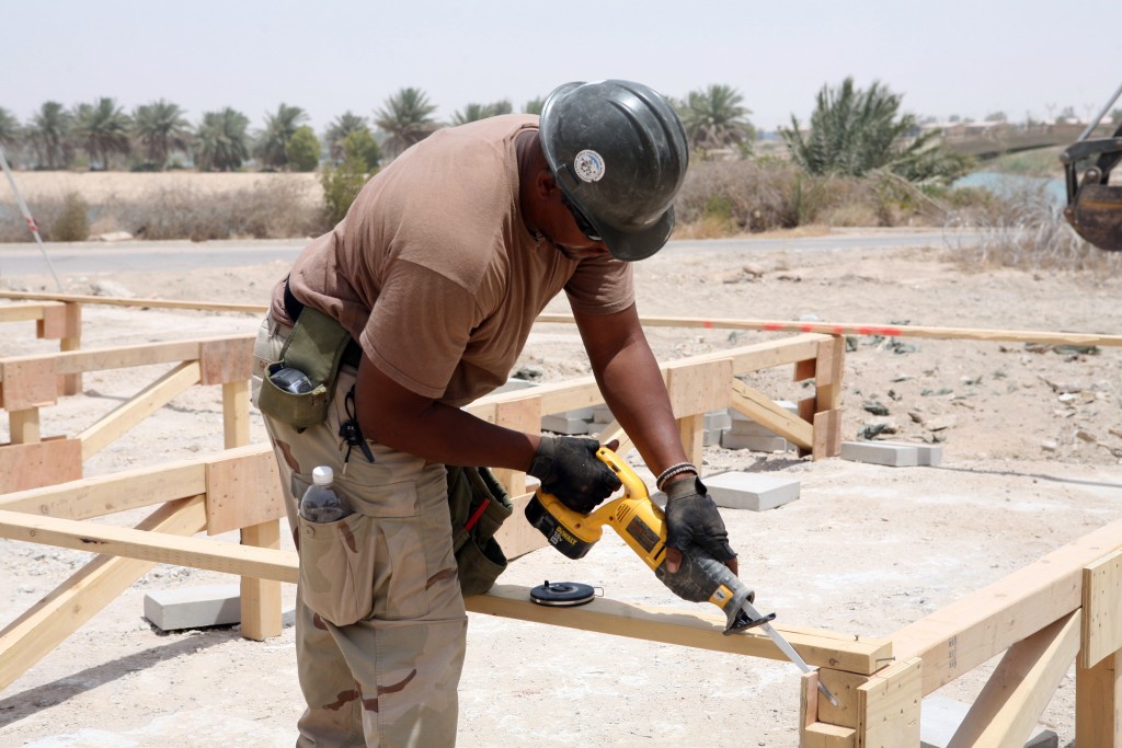 080719-N-9623R-008 FALLUJAH, Iraq (July 19, 2008) Builder 2nd Class Thomas, assigned to Naval Mobile Construction Battalion (NMCB) 17, modifies gussets on a South Western Asia (SWA) hut foundation. The foundation is a unique design created by NMCB-17 builders consisting of 4x4s and 25 load-bearing post versus standard SWA hut 15 post construction. NMCB-17, also known as the "Desert Battalion," is deployed to Iraq and other areas of operations supporting Operation Iraqi Freedom and Enduring Freedom. (U.S. Navy photo by Mass Communication Specialist 2nd Class Kenneth W. Robinson/Released)